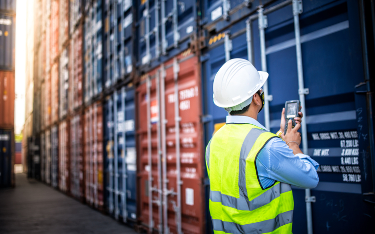 Foreman checking import export documentation at a warehouse