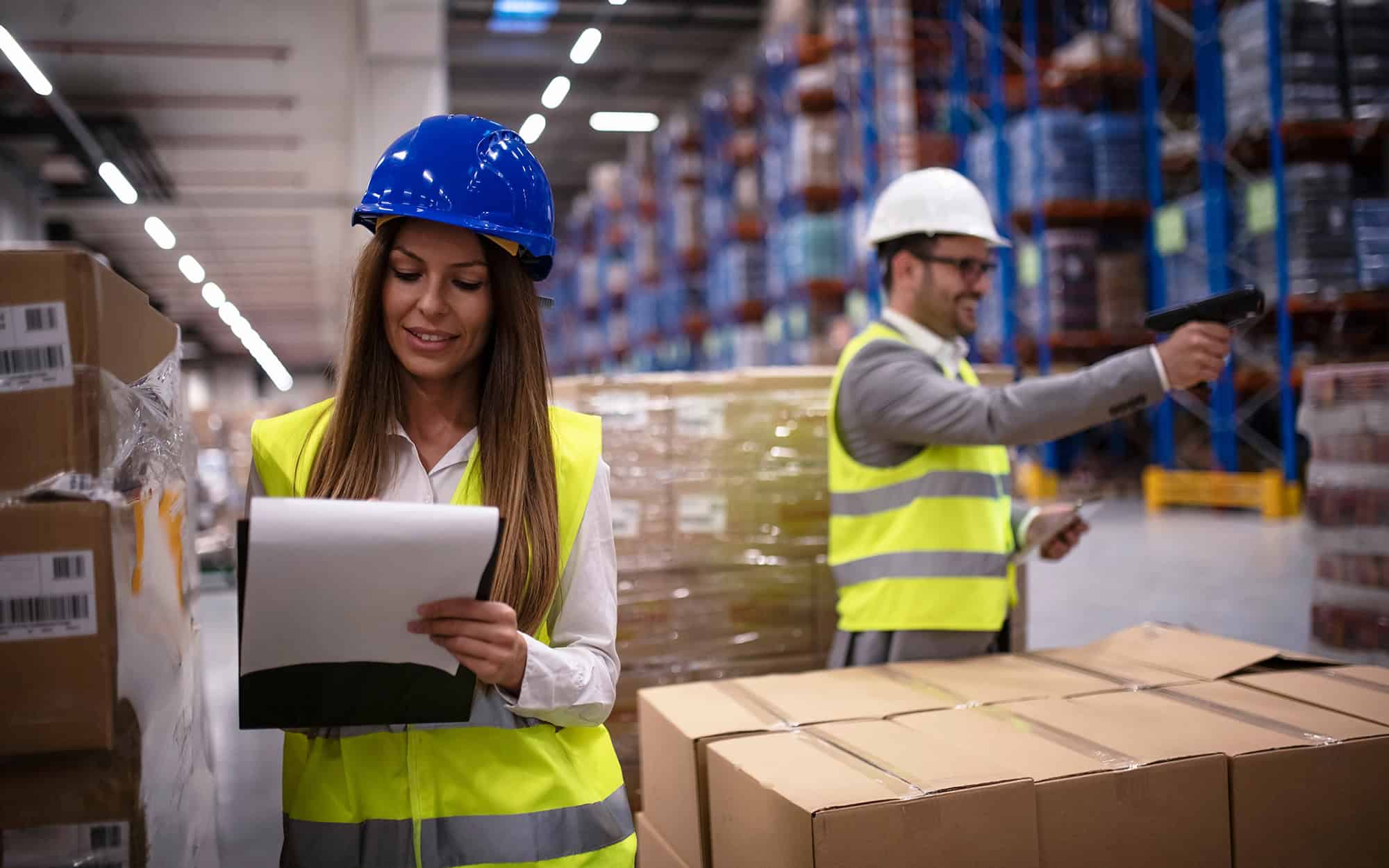 Warehouse staff checking cartons against a clipboard