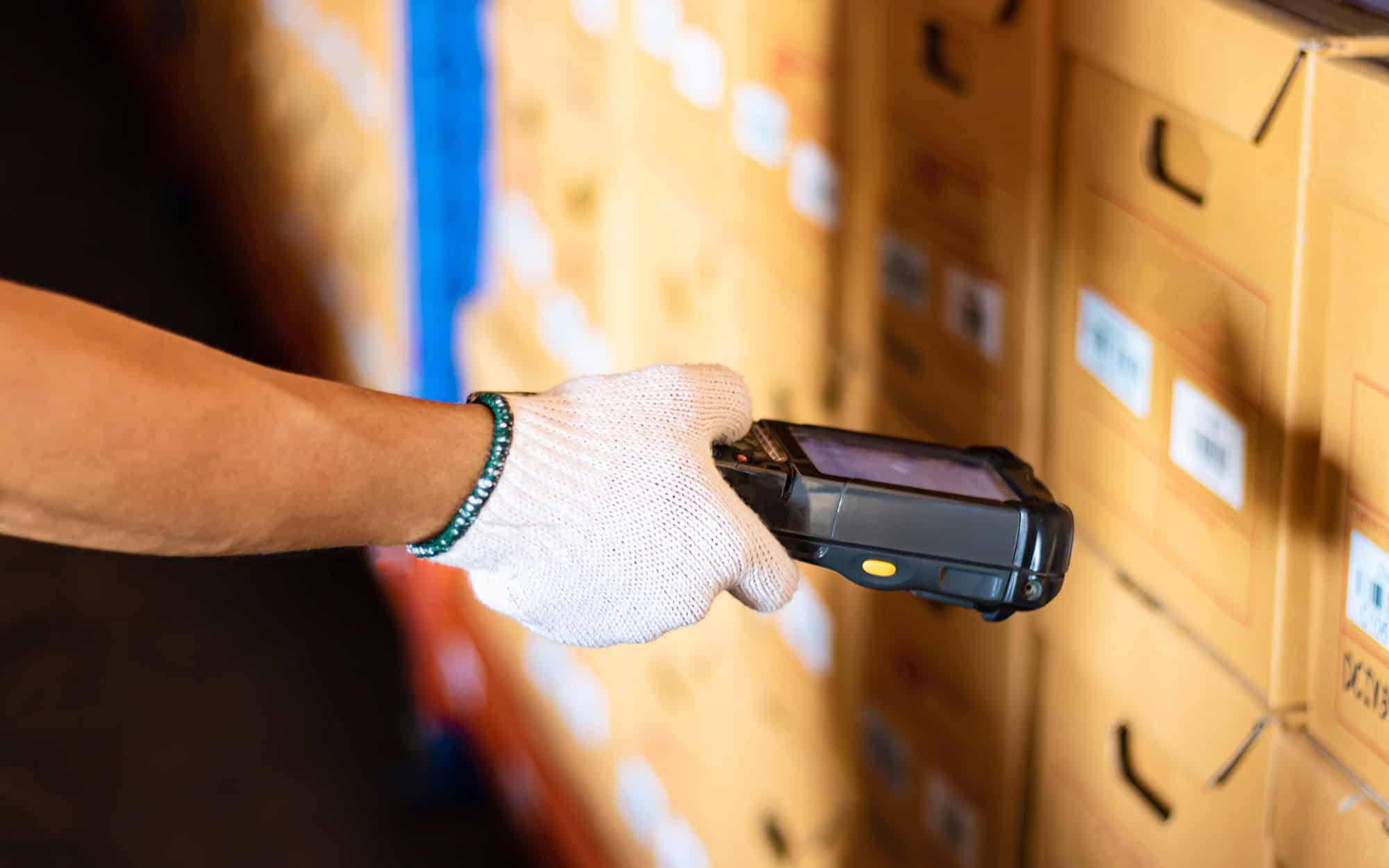 Warehouse scanner reading carton labels on imported goods