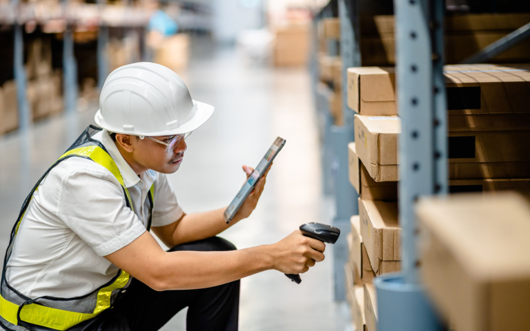 Warehouse worker scanning boxes on a shelf