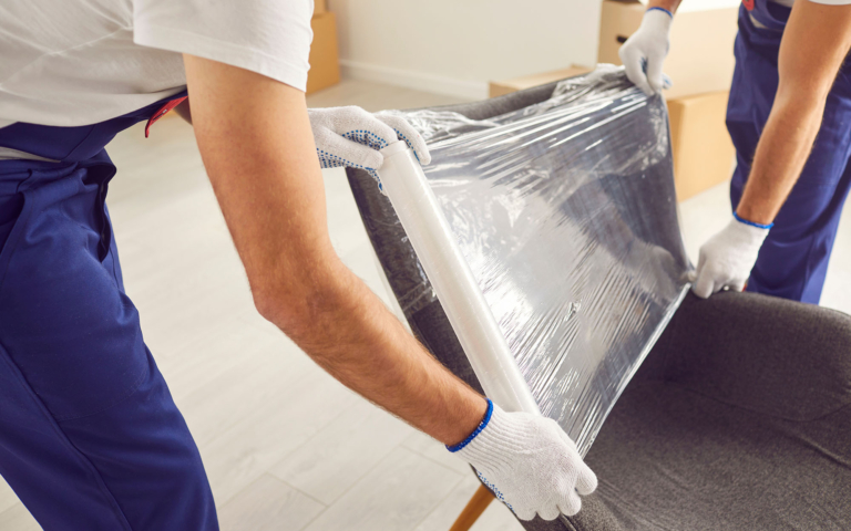 Workers wrapping furniture for transit