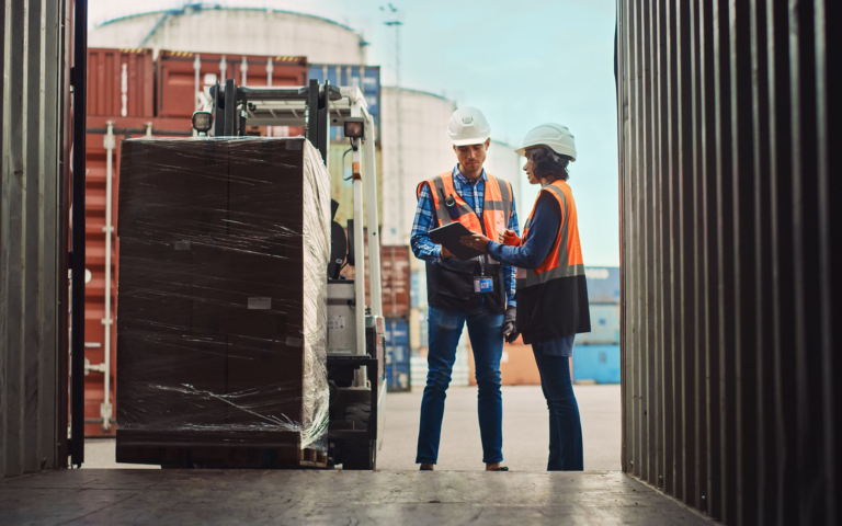 Workers consolidating freight inside a cargo container