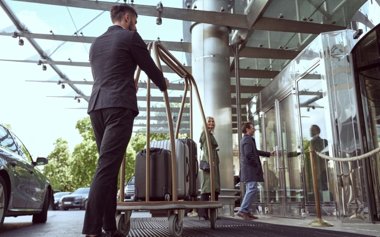 Hotel worker moving guest supplies on a cart