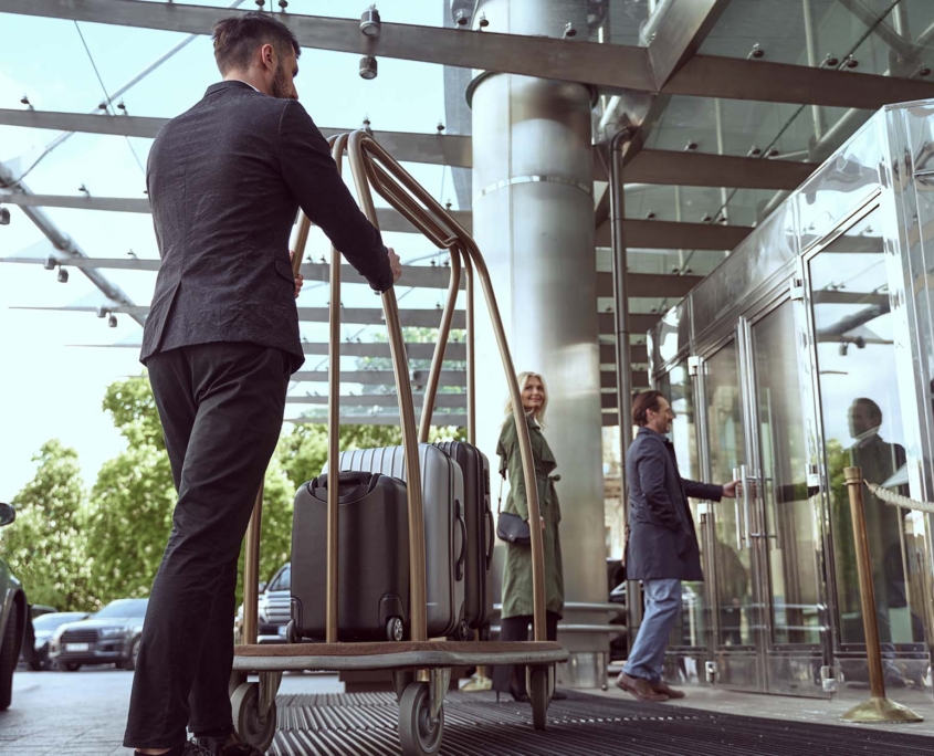 Hotel worker taking bags on a cart