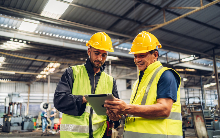 Industrial workers reviewing a tablet