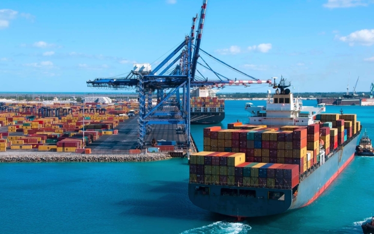 Ocean cargo ship being guided into dock