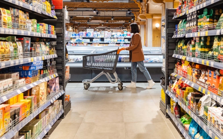 Shopper walking a supermarket aisle