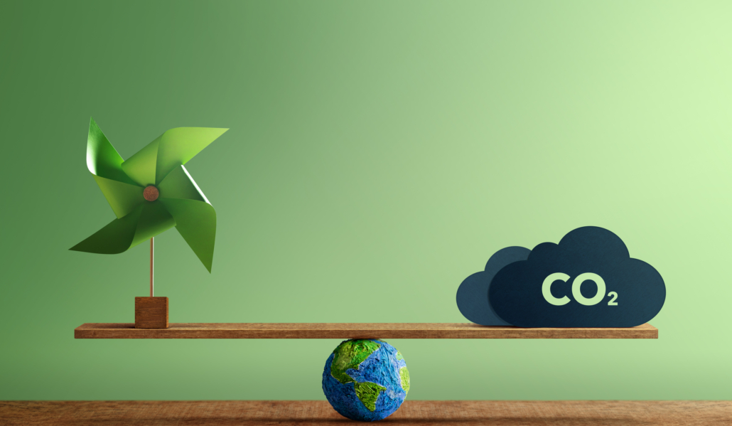 Carbon Neutral and ESG Concepts. Carbon Emission, Clean Energy. Globe Balancing between a Wind Turbine and CO2