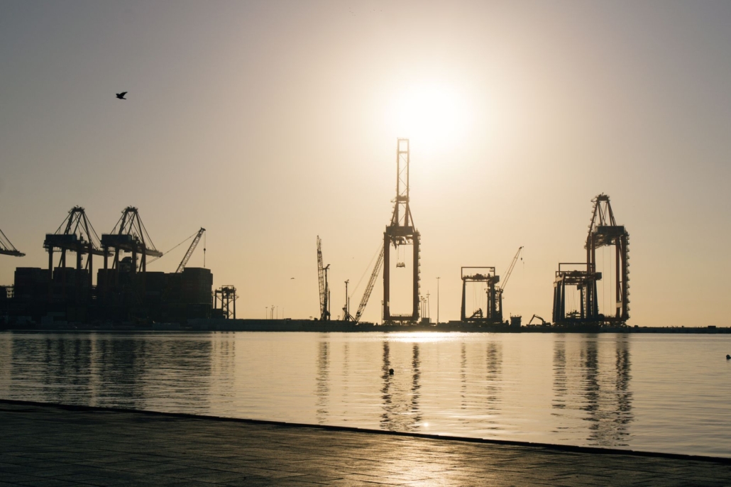 Silhouetted port cranes at sunrise