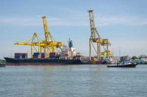 Cargo ship with cranes at an industrial port