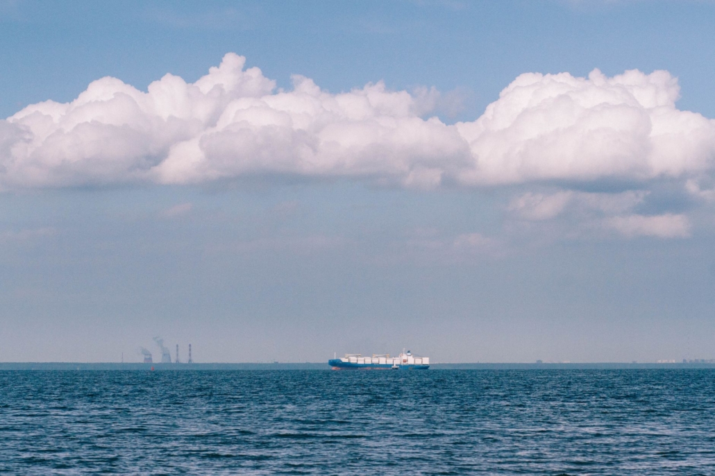 Distant cargo ship under a dramatic sky