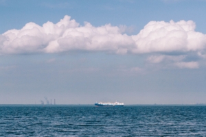 Distant cargo ship under a dramatic sky