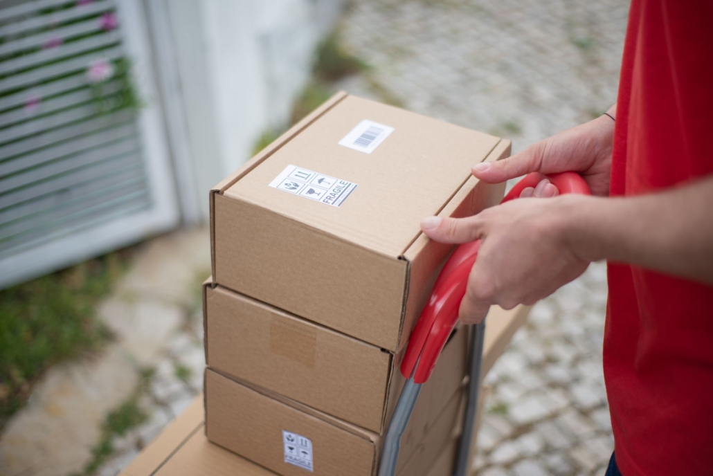 Stacked parcels with shipping labels on a hand trolley