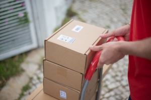 Stacked parcels with shipping labels on a hand trolley