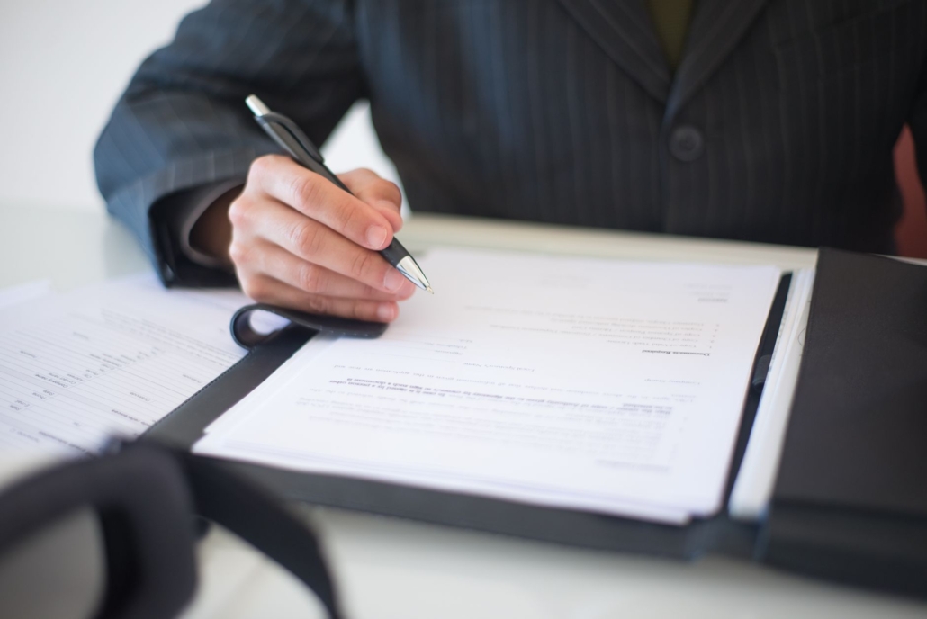 Executive signing an import declaration document at a desk